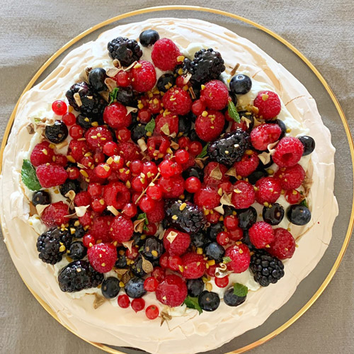 Paulova de frambuesas, grosellas, arándanos y pistacho